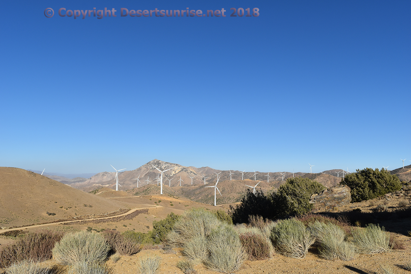 Image showing multiple wind turbines among the hills